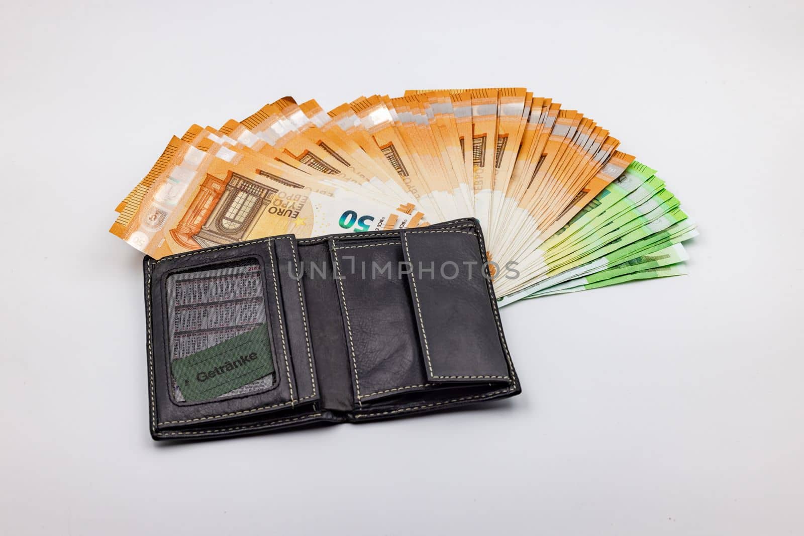 Wealth in a purse with a fan of euro banknotes against a white background in the studio