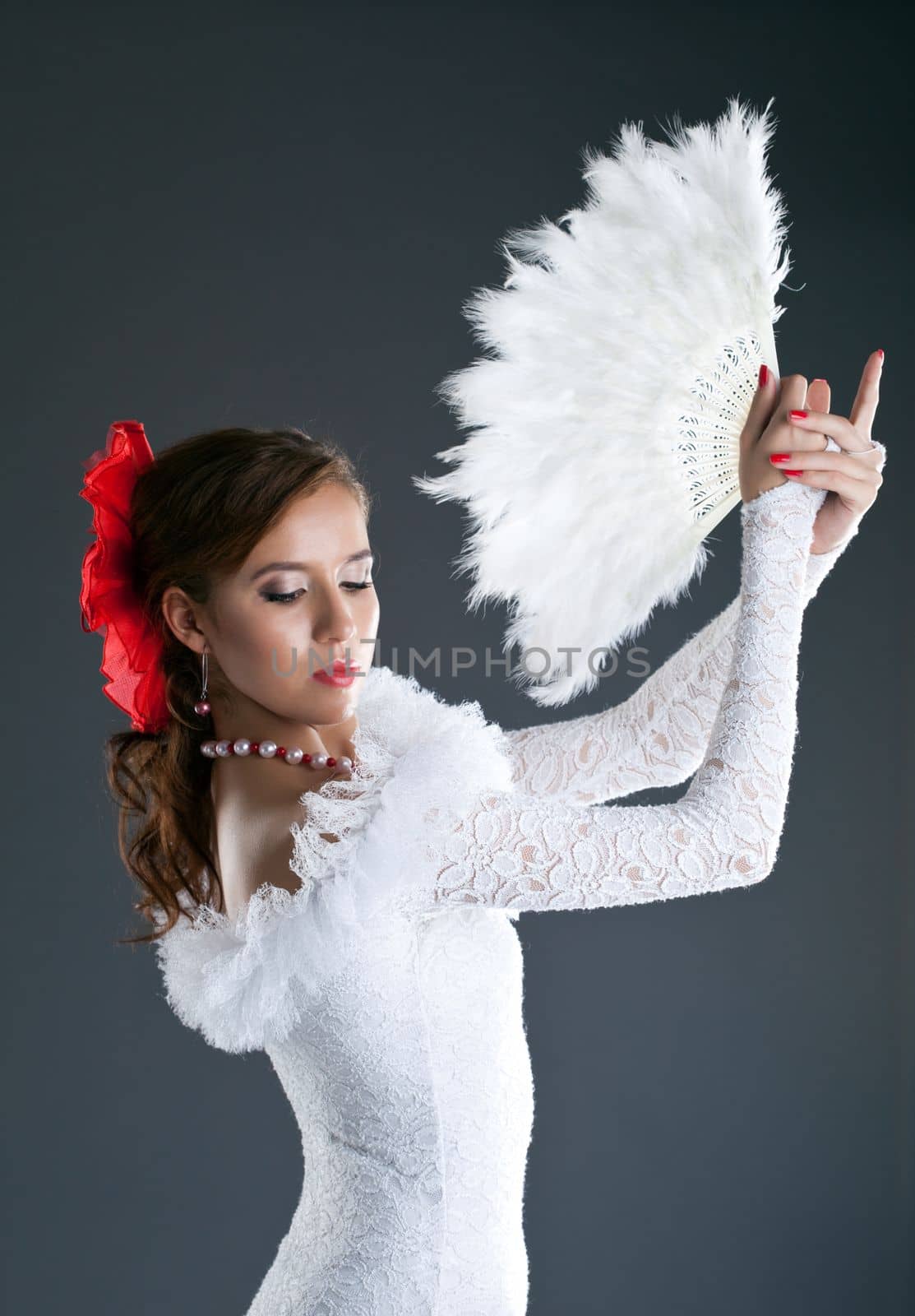 woman posing in flamenco white costume with fantail