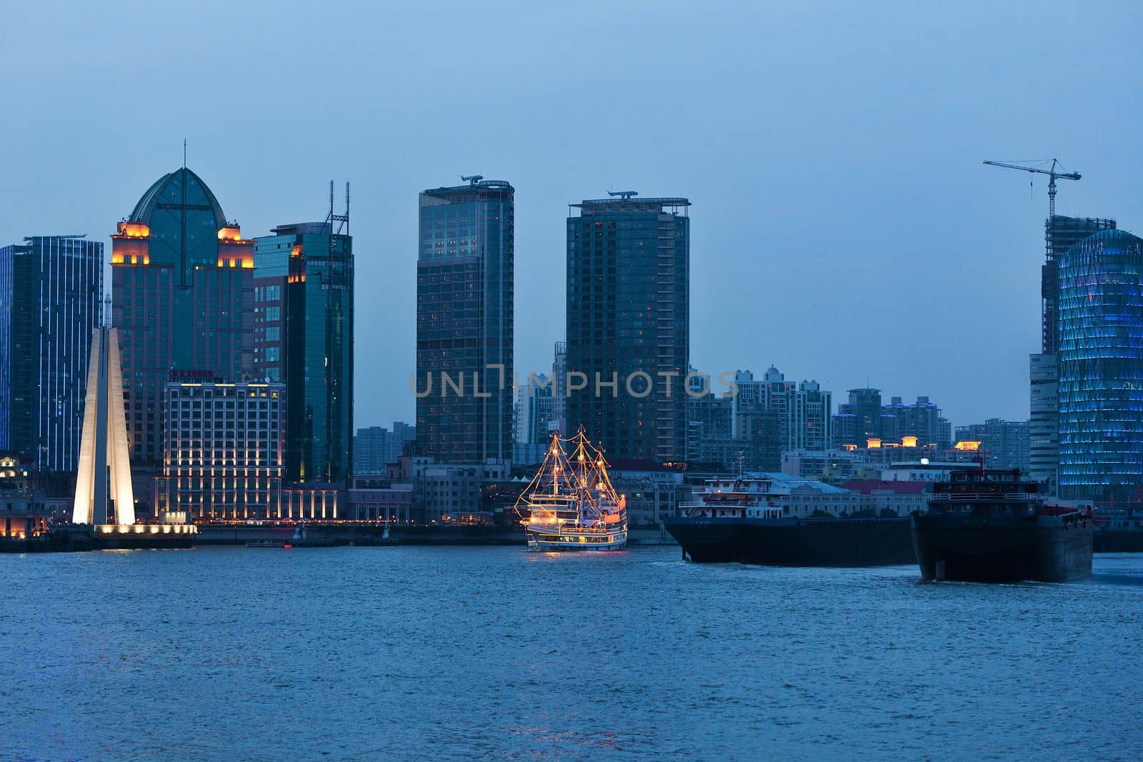 Shanghai skyscrapers near water at night with mirror