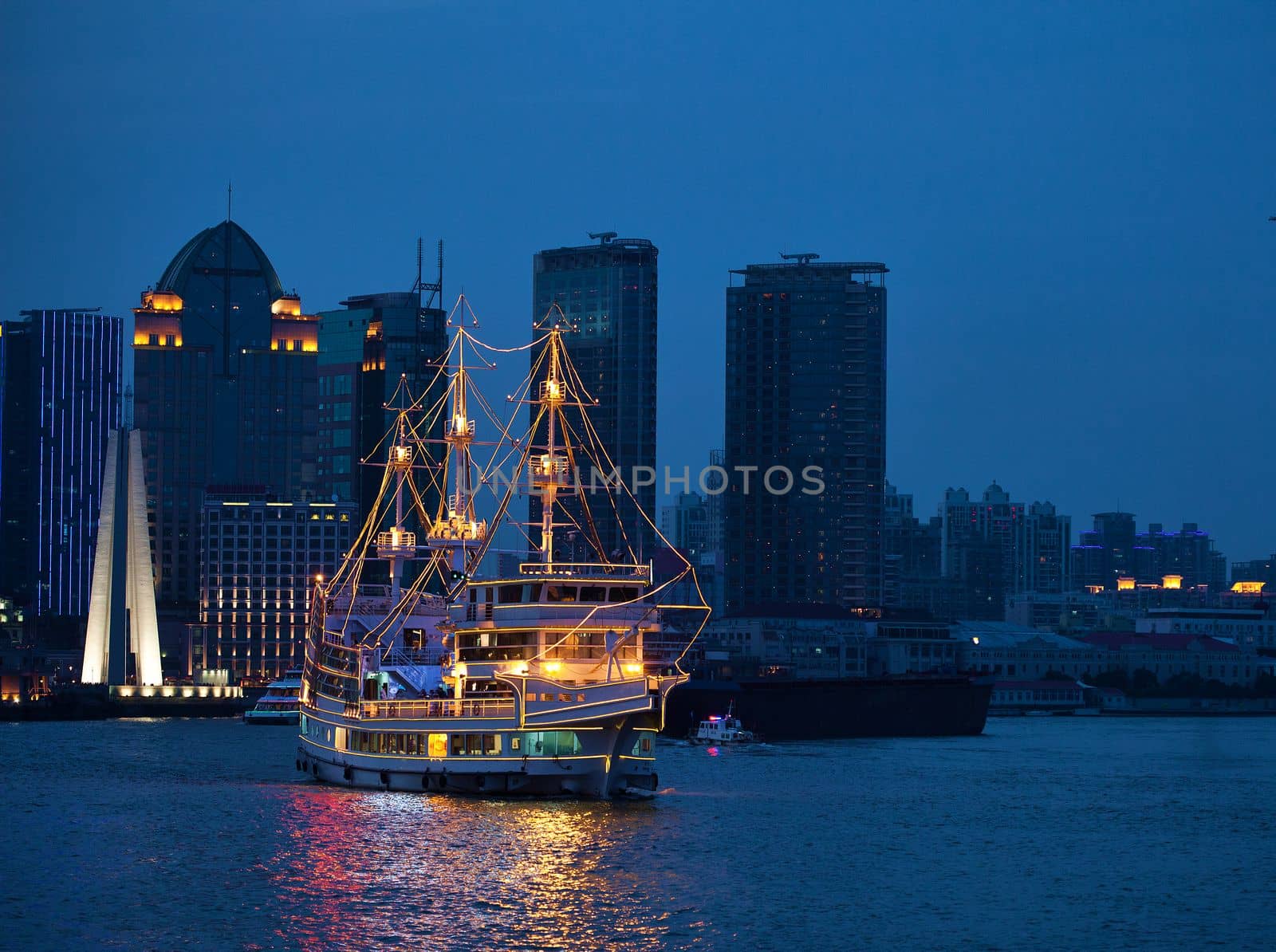 Shanghai skyscrapers at night and old style ship