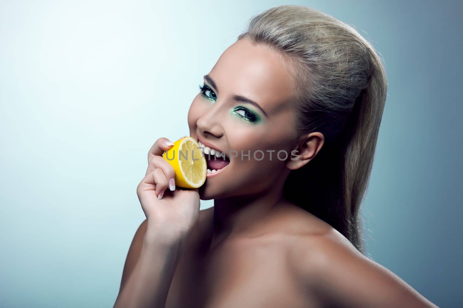 Beautiful young woman smile and taste lemon