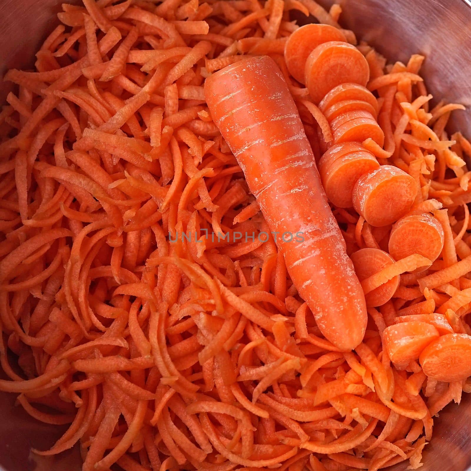 Carrots, grated, sliced ​​and whole in a metal dish