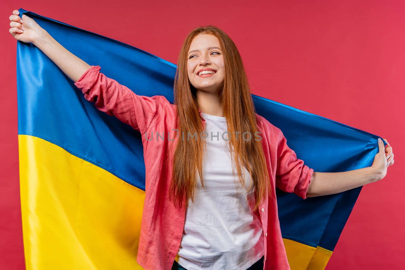 Happy woman with national Ukrainian flag on pink viva magenta. Ukraine, patriot, victory in war celebration, banner, Independence day. High quality photo