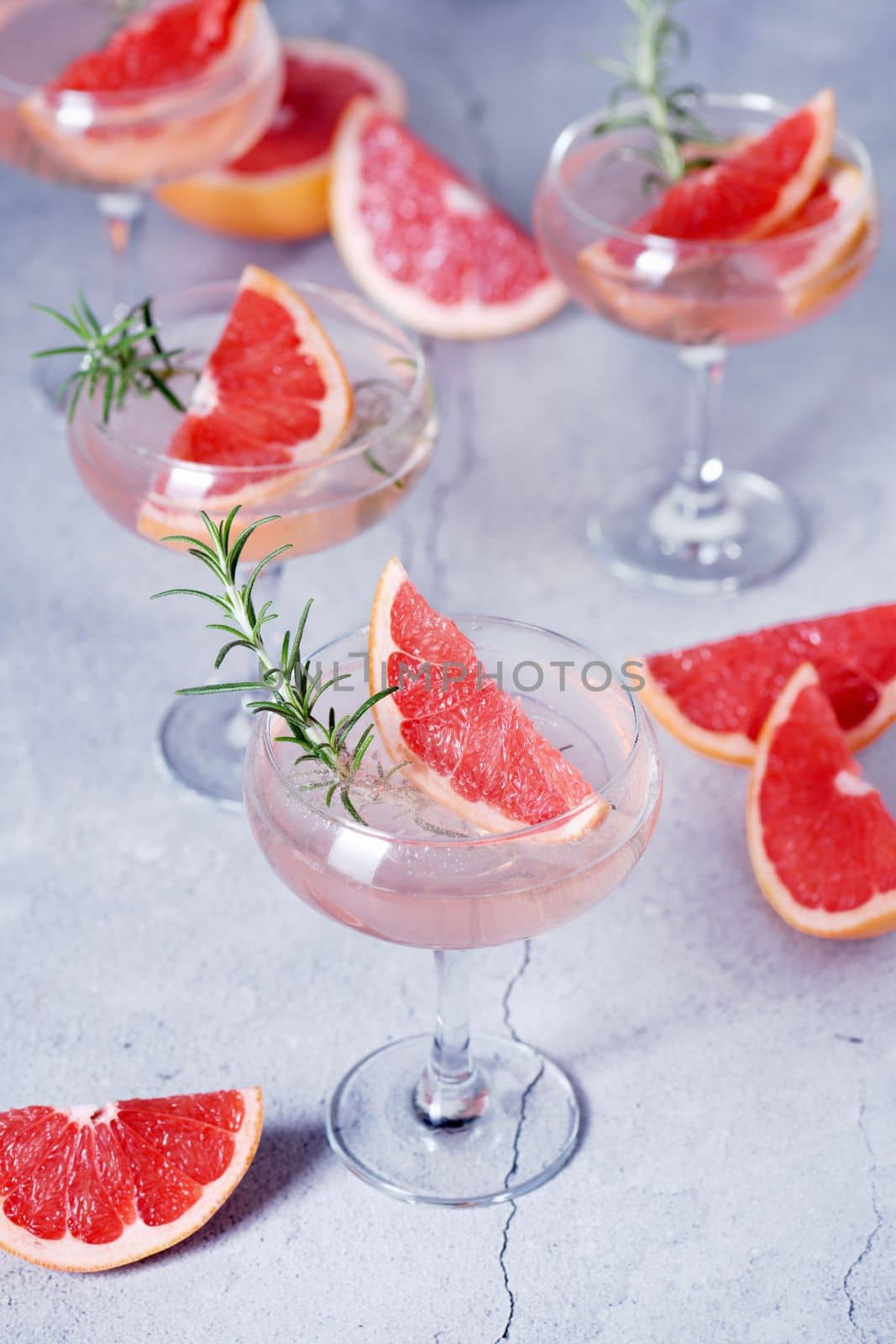 Goblet of sparkling wine with a slice of grapefruit and a sprig of rosemary