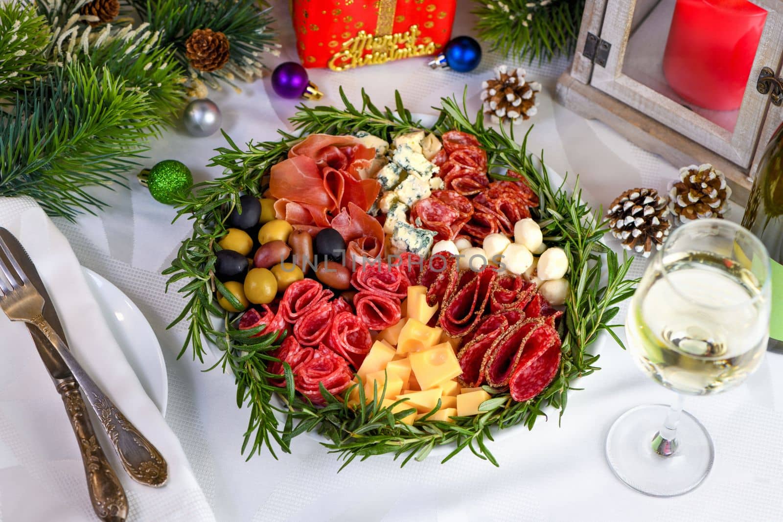 Delicacy assorted appetizer platter of salami and cheese, Parma ham, olives. An original antipasto serving for a Christmas party.