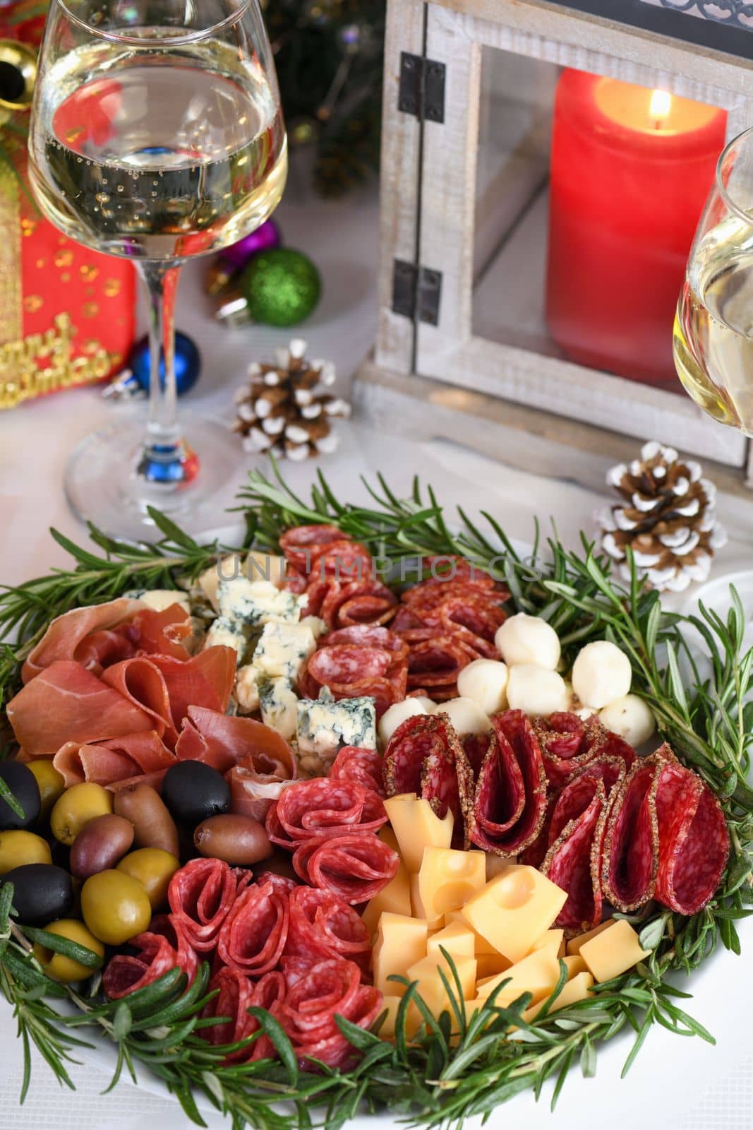 Delicacy assorted appetizer platter of salami and cheese, Parma ham, olives. An original antipasto serving for a Christmas party.