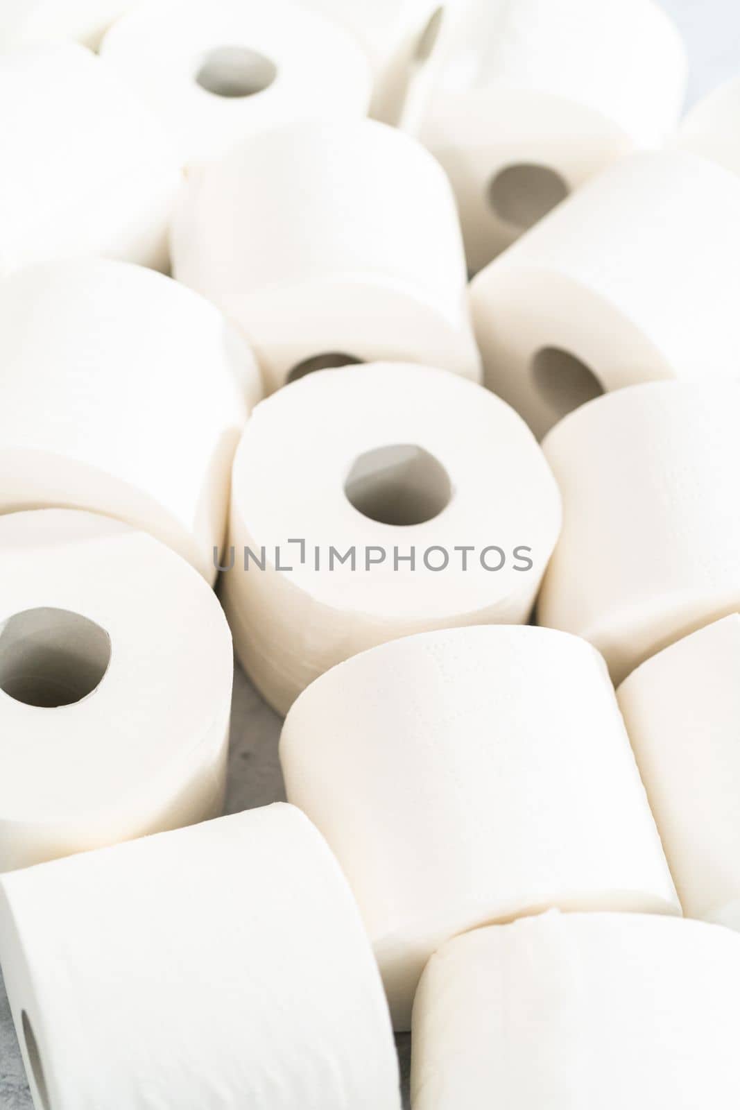 New white toilet paper rolls on a gray background.