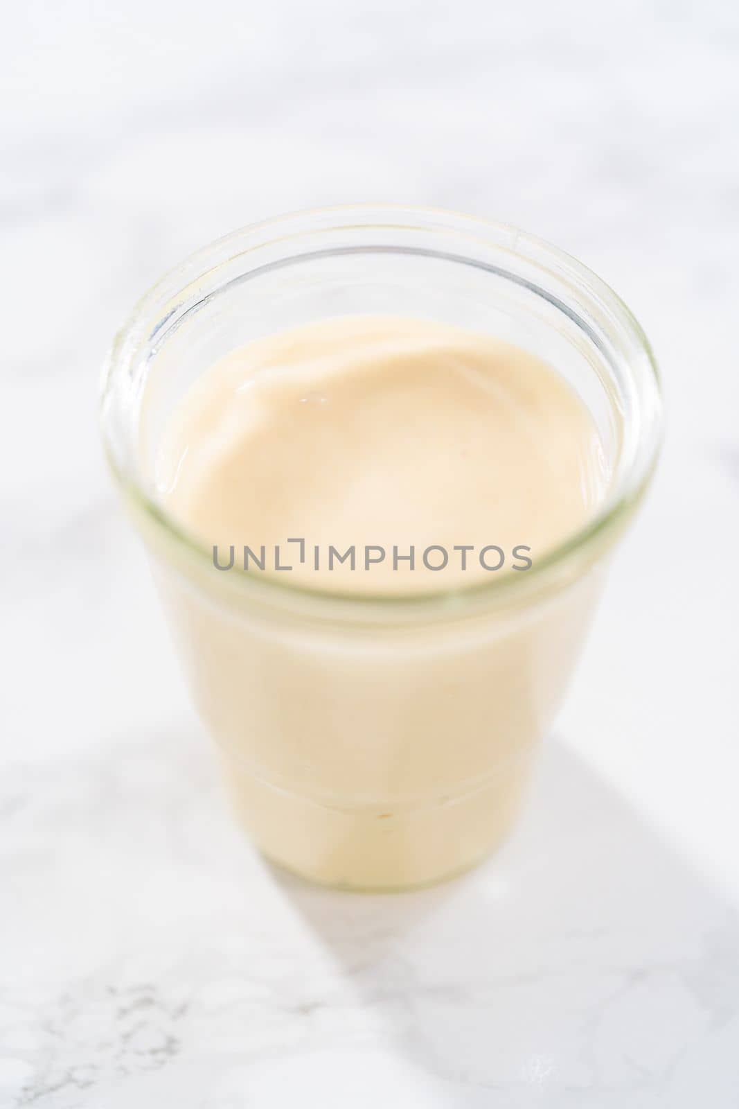 Eggnog glaze in a small glass jar.