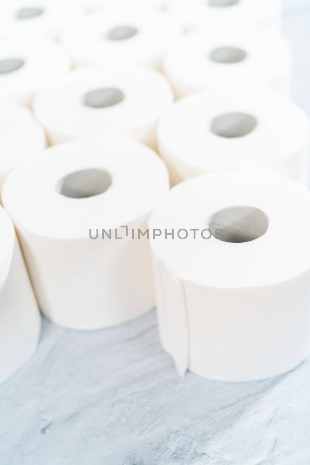 New white toilet paper rolls on a gray background.