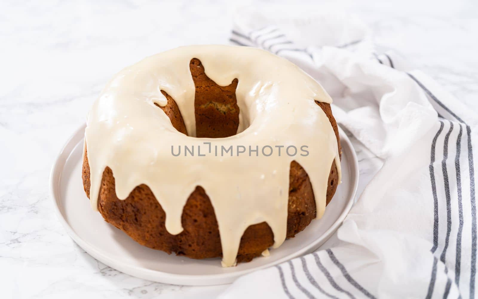Slicing homemade eggnog bundt cake with an eggnog glaze.