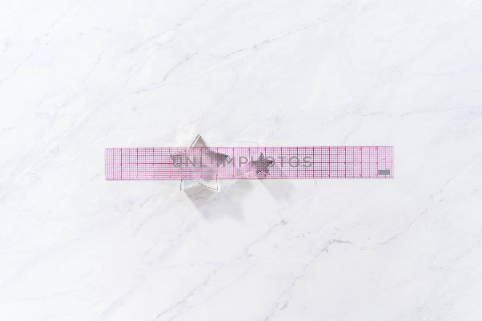 Flat lay. Star-shaped cookie cutters next to the ruler on the kitchen counter.