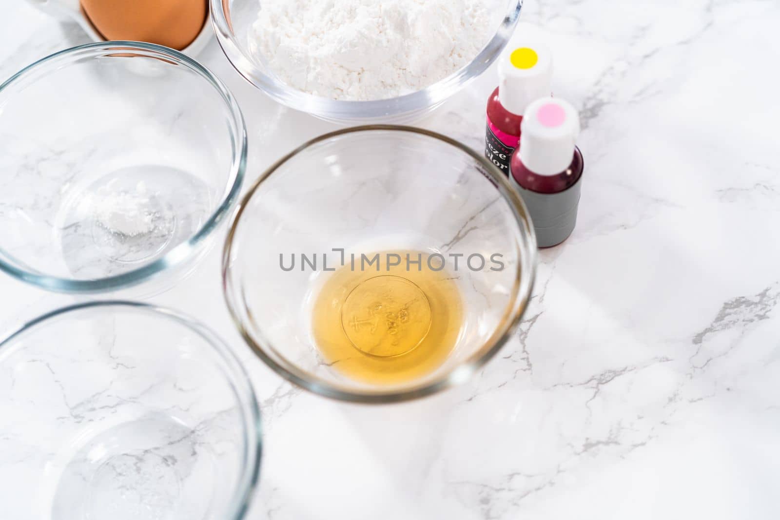 Measured ingredients in glass mixing bowls to bake Easter meringue cookies.