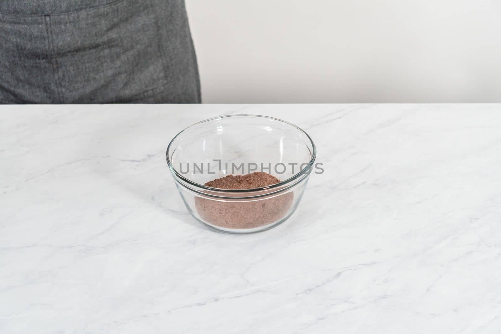 Mixing ingredients in a glass mixing bowl to bake chocolate graham crackers.