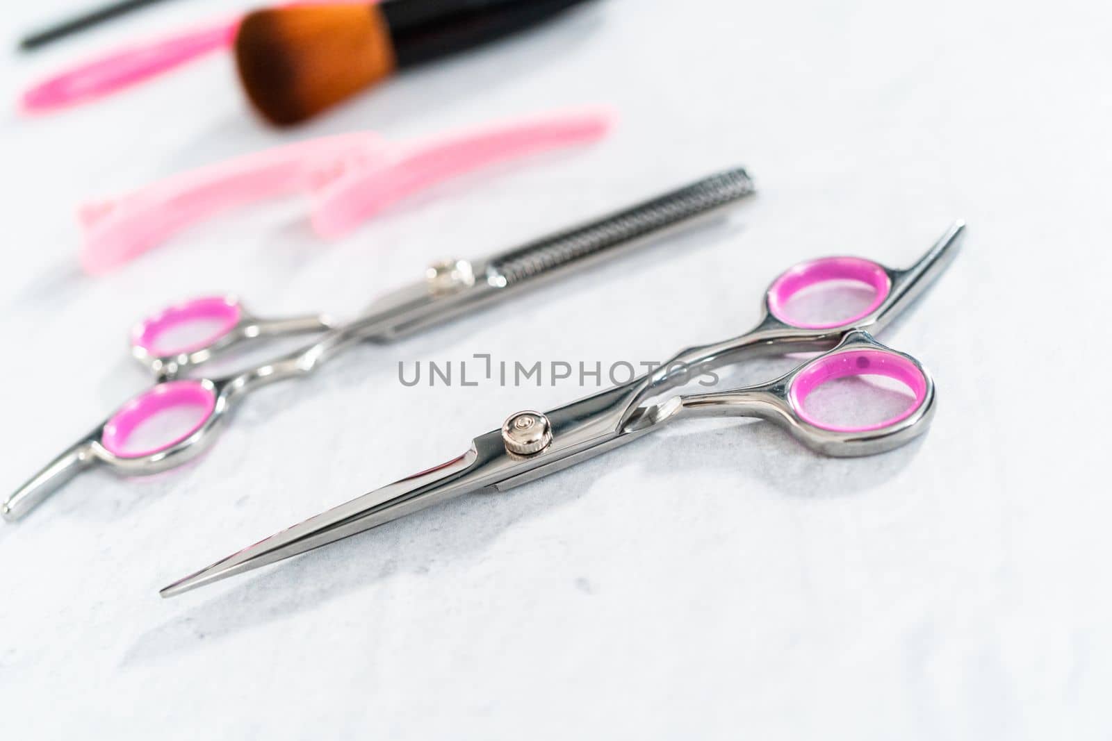 New barber pink scissors on a gray background.