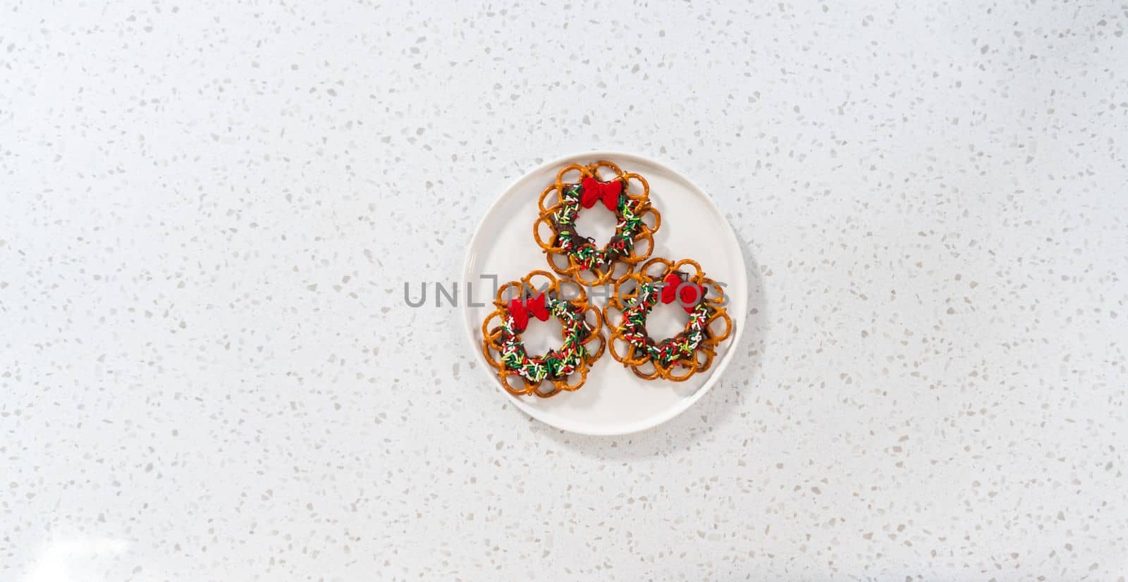 Flat lay. Chocolate pretzel Christmas wreath on a white plate.