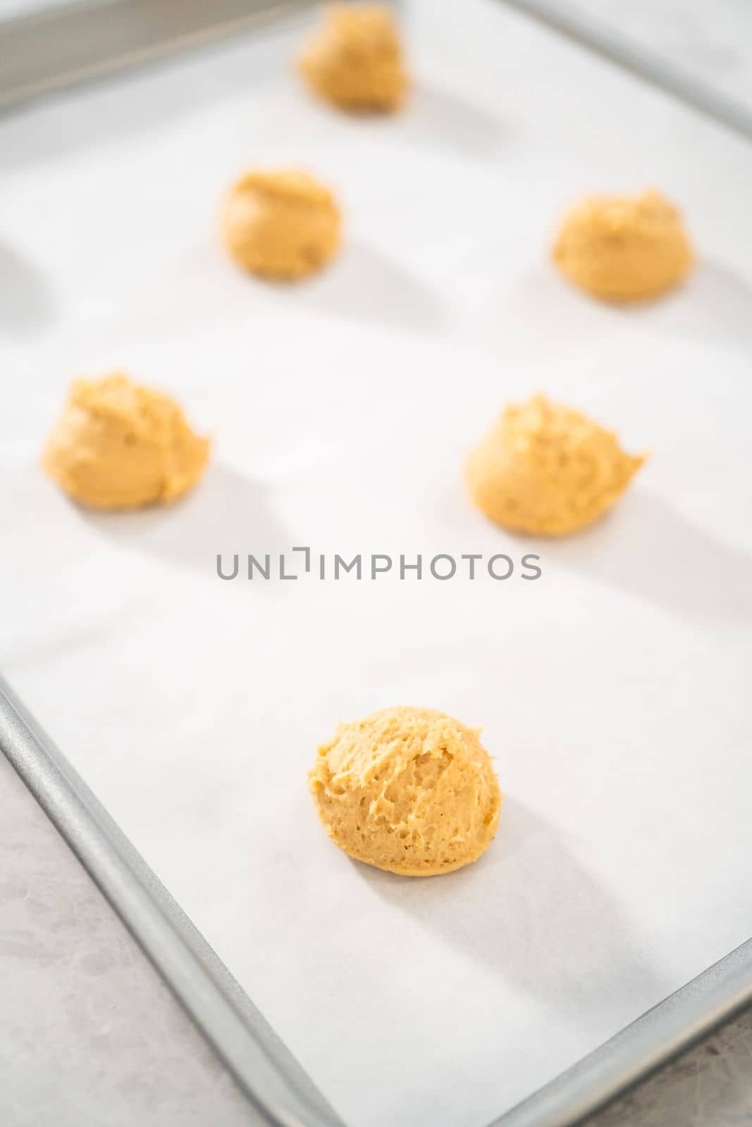 Scooping dough with dough scoop to bake eggnog scones.
