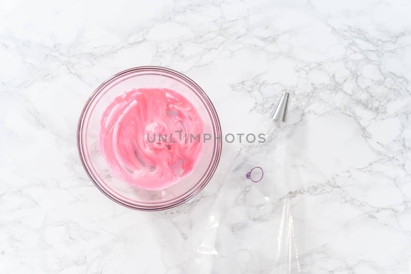 Mixing pink food coloring into the meringue to bake Easter meringue cookies.