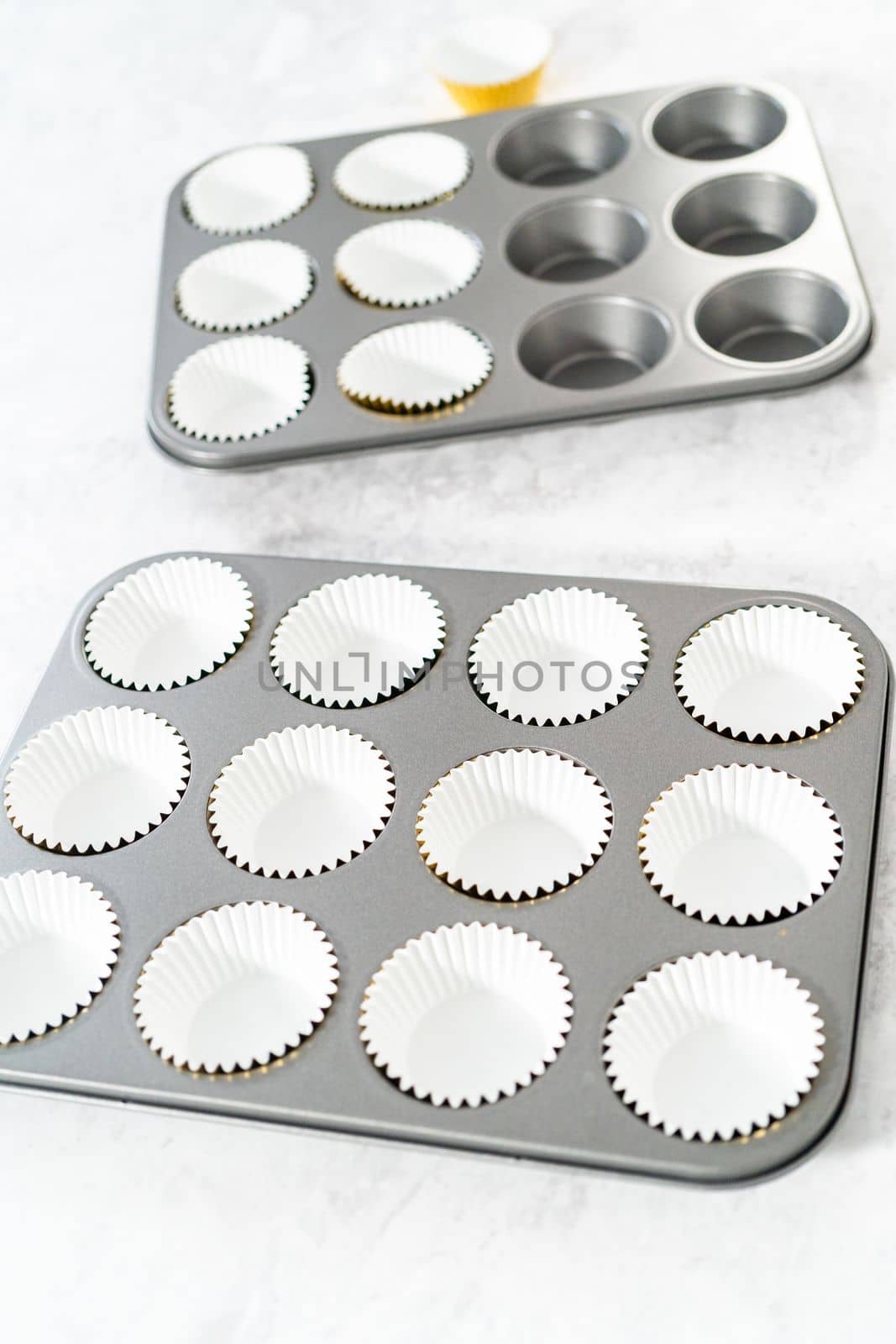 Lining cupcake pan with foil cupcake liners to bake s'mores cupcakes.