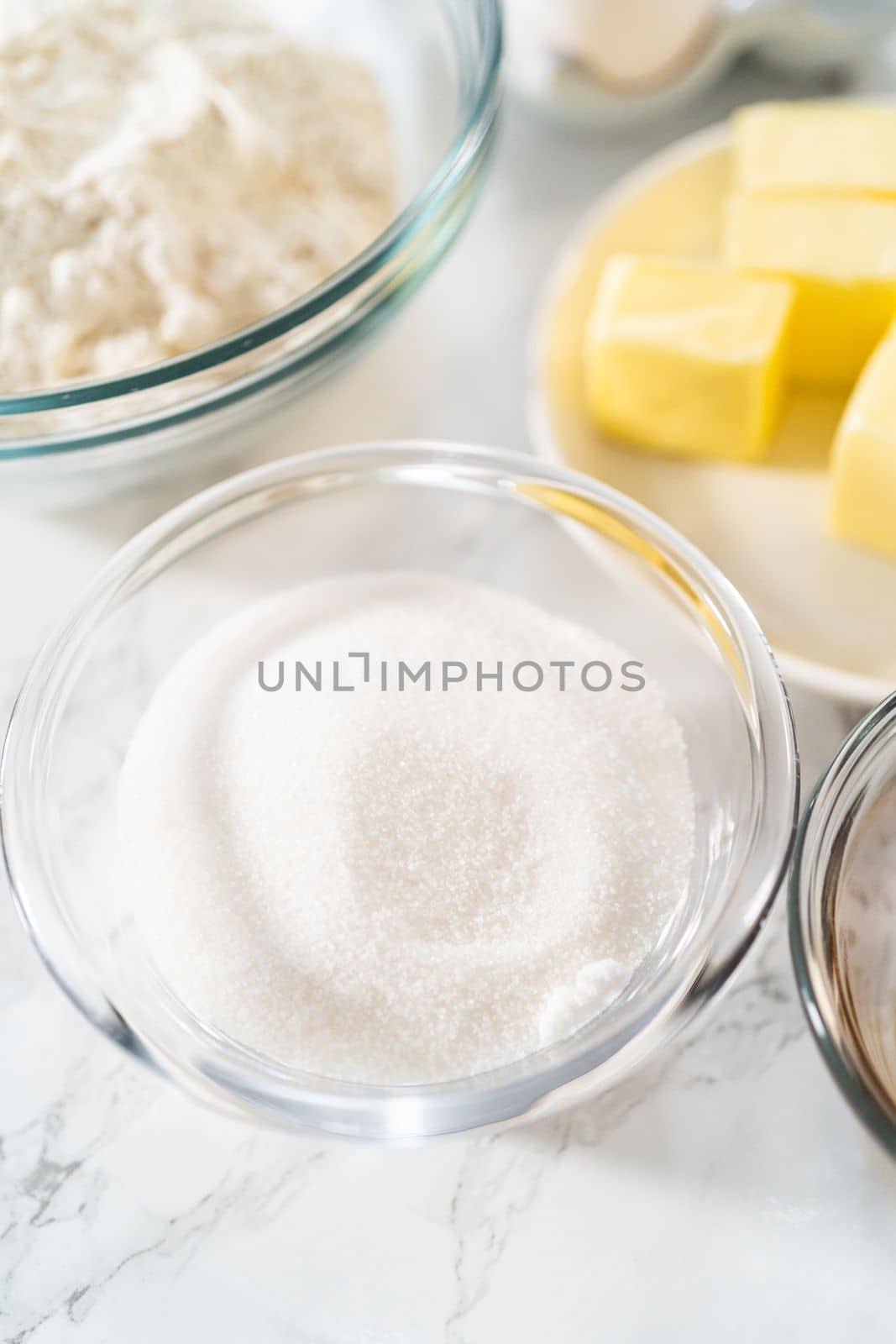 Measured ingredients in glass mixing bowls to bake mini vanilla cupcakes with ombre pink buttercream frosting.