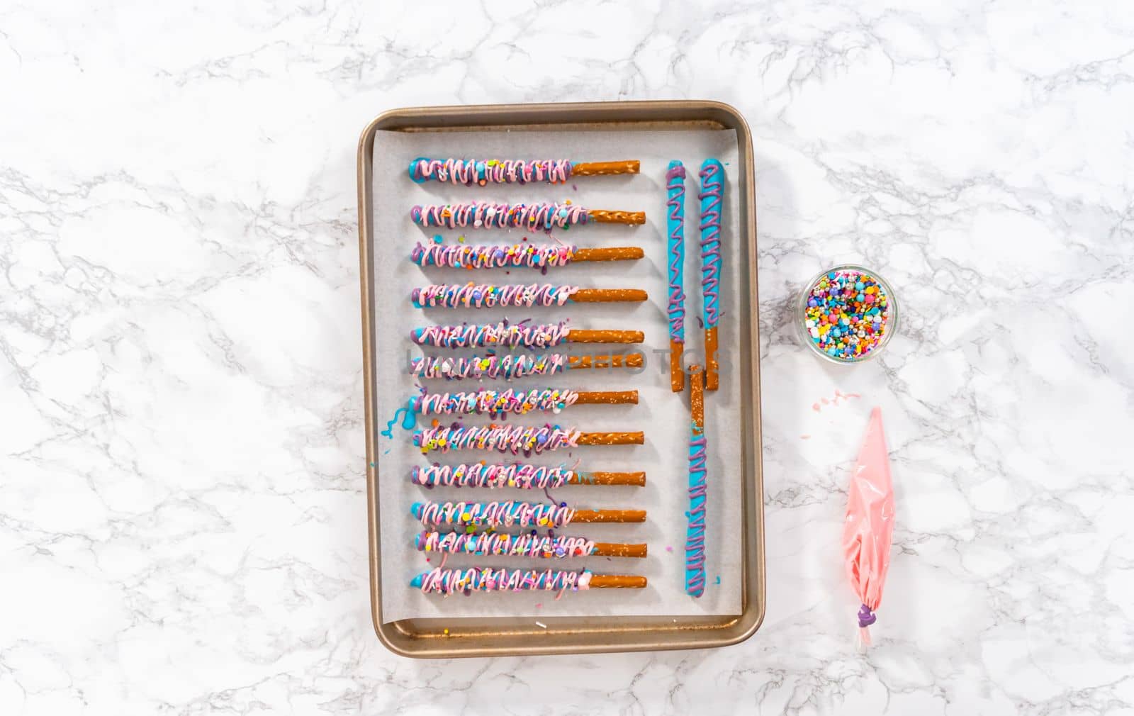 Mermaid chocolate pretzel rods drizzled with pink and purple chocolate and covered with sprinkles.