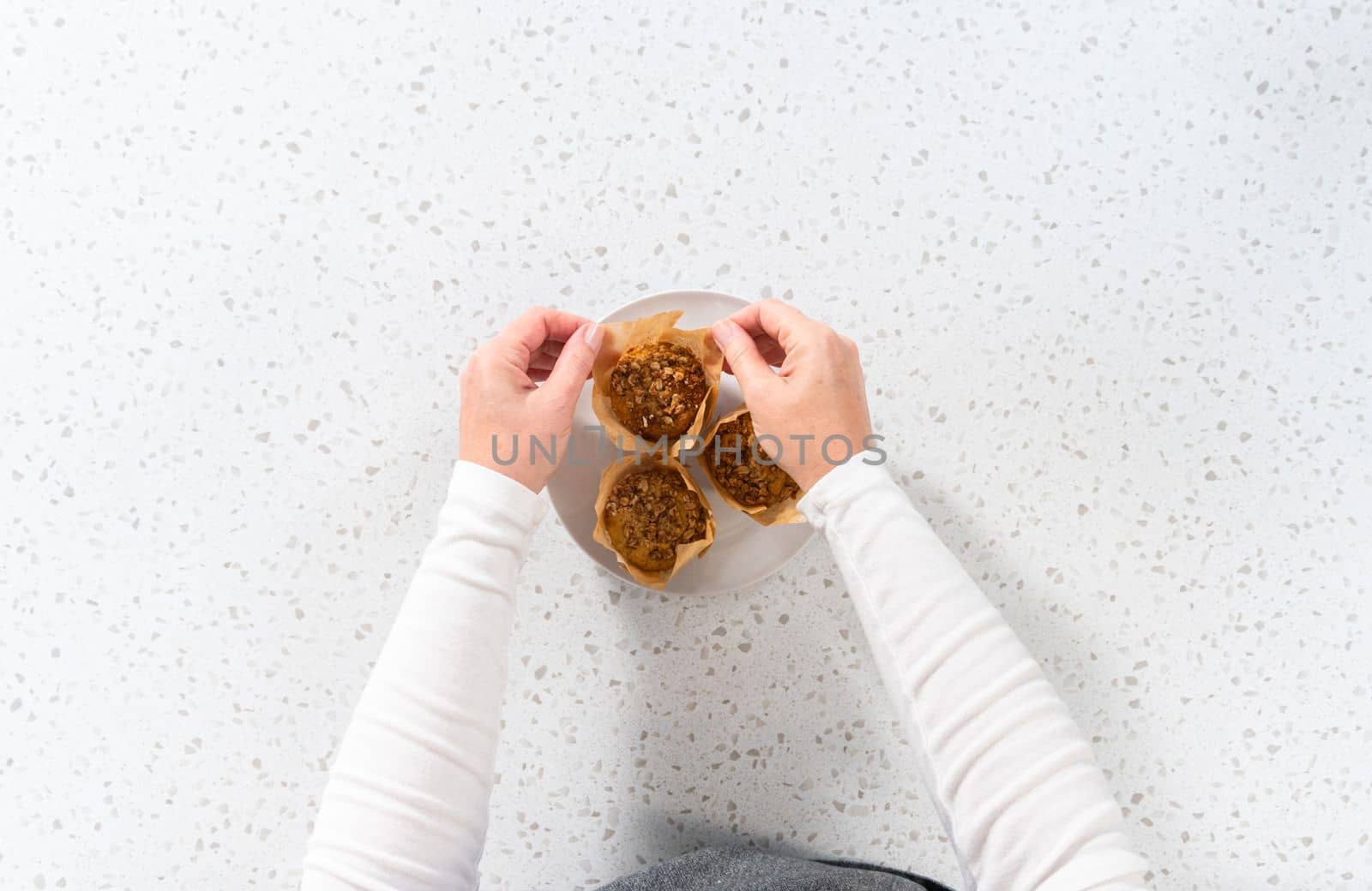 Flat lat. Freshly baked banana oatmeal muffins on a small white plate.