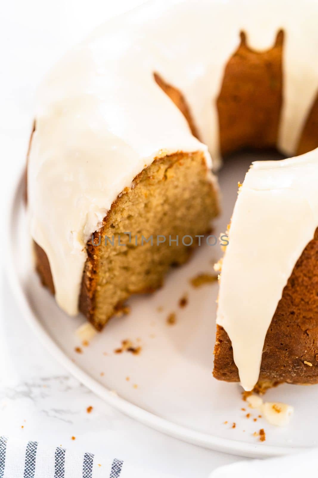 Slicing homemade eggnog bundt cake with an eggnog glaze.