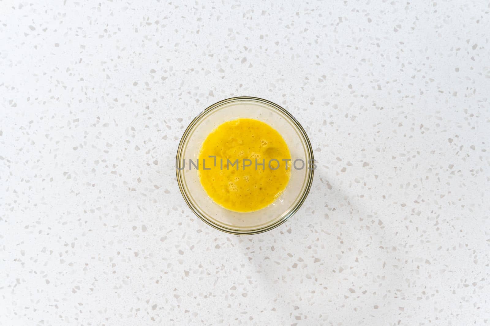 Flat lay. Mixing ingredients in a glass mixing bowl to prepare filling for breakfast empanadas with eggs and sweet potato.