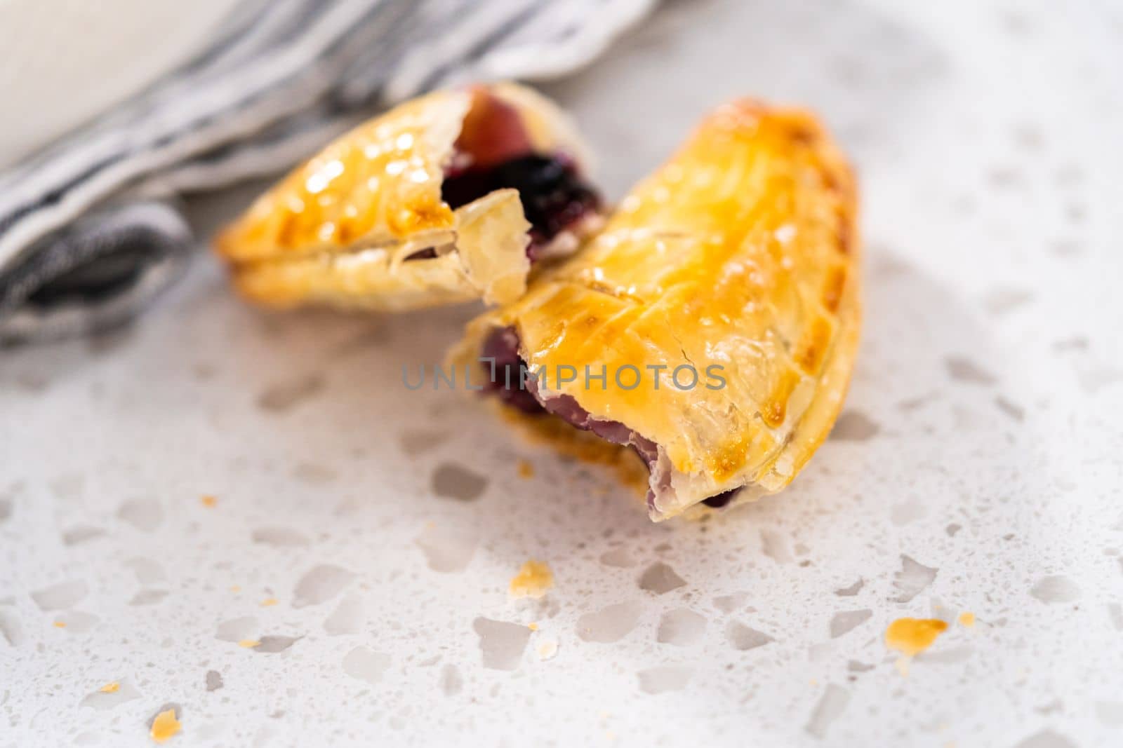 Freshly baked sweet empanadas with blueberries on the kitchen counter.
