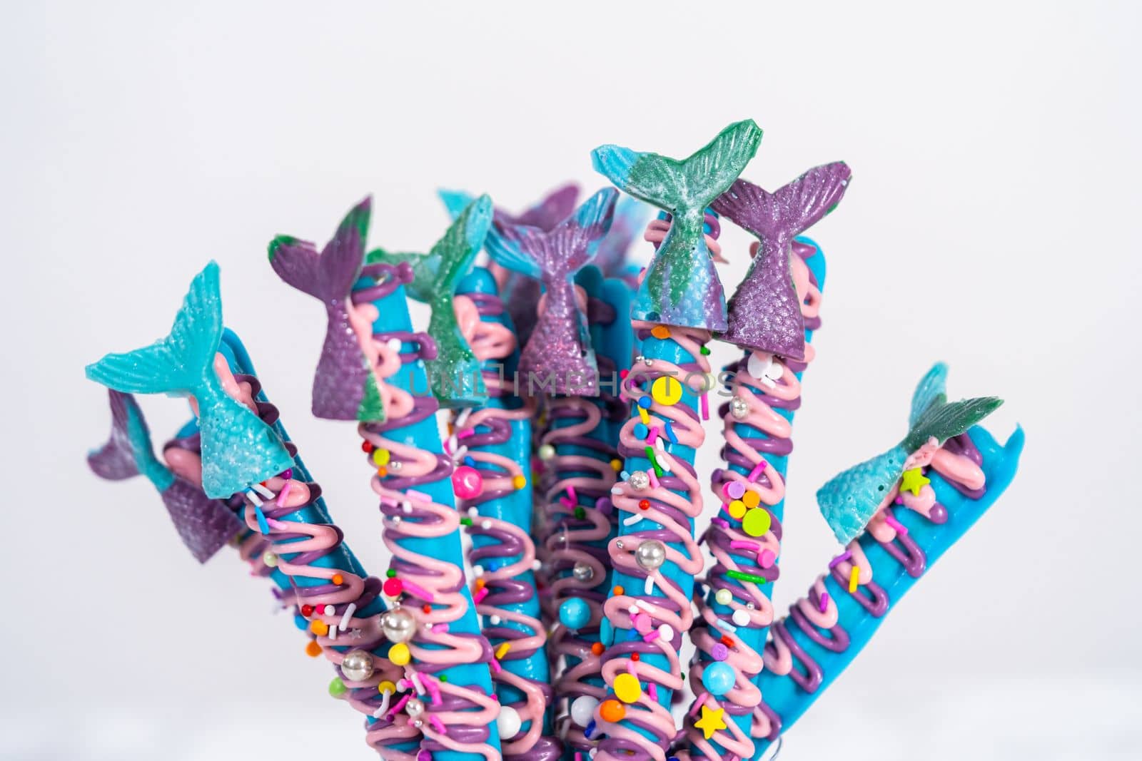 Mermaid chocolate pretzel rods drizzled with pink and purple chocolate and covered with sprinkles.