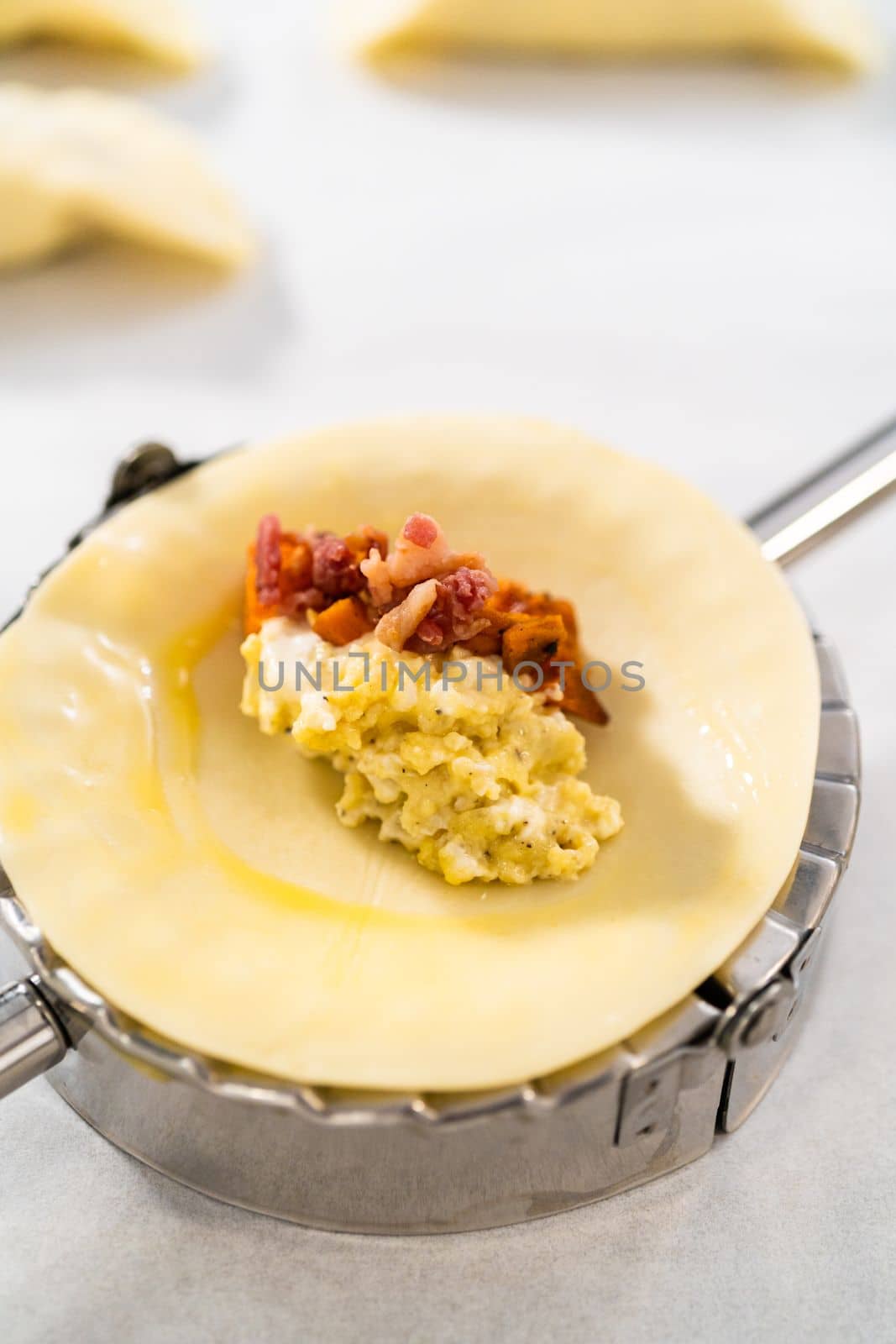 Filling empanada dough with egg filling to make breakfast empanadas with eggs and sweet potato.