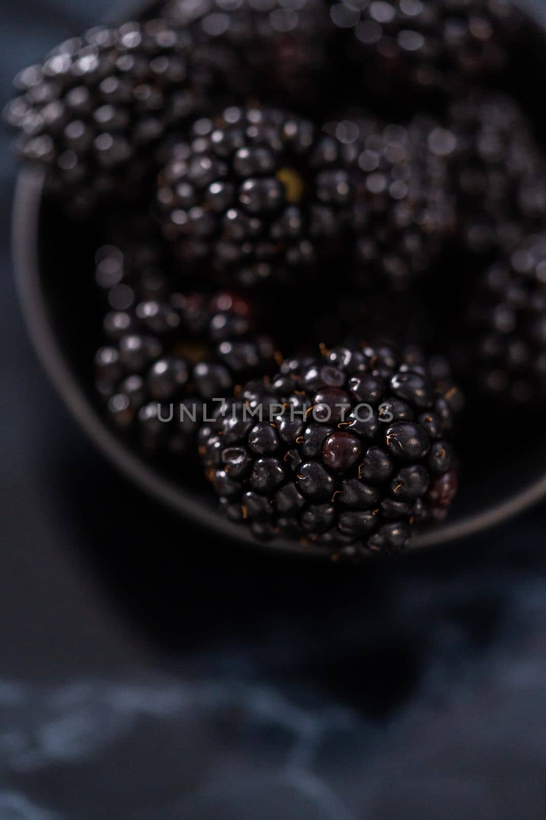 Fresh organic blackberries on ablack marble surface.