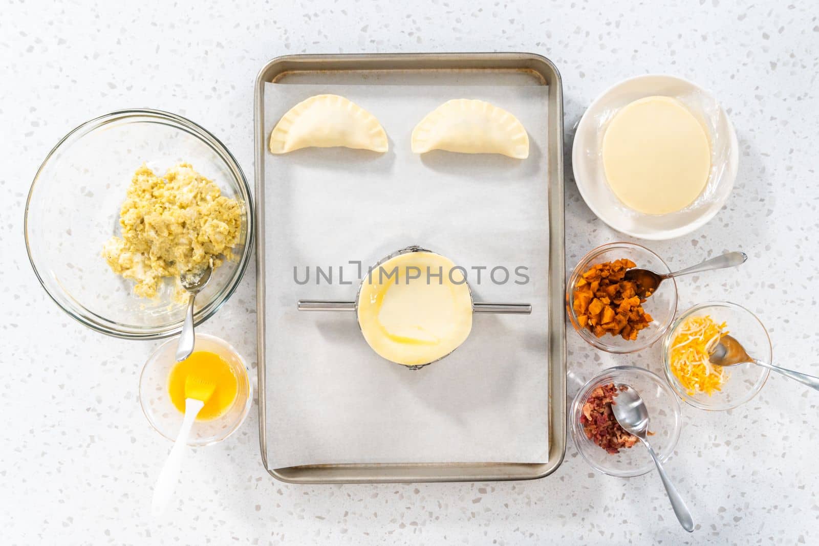 Flat lay. Filling empanada dough with egg filling to make breakfast empanadas with eggs and sweet potato.