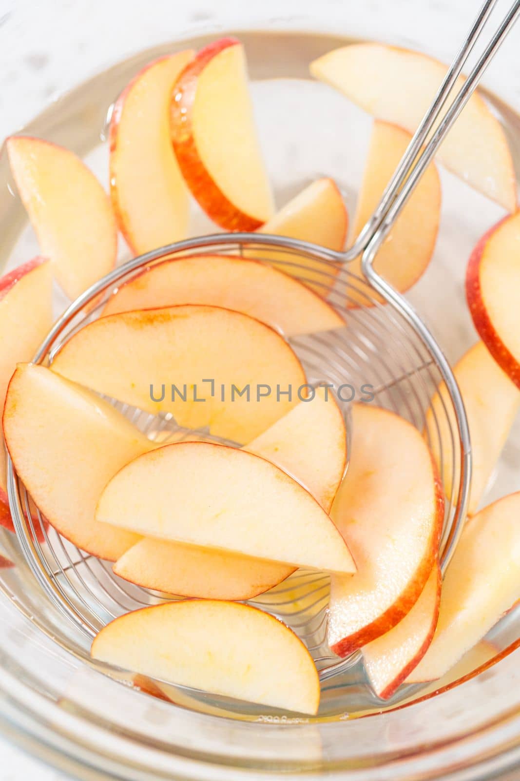 Washing apple slices in the water mixture to prevent them from browning.