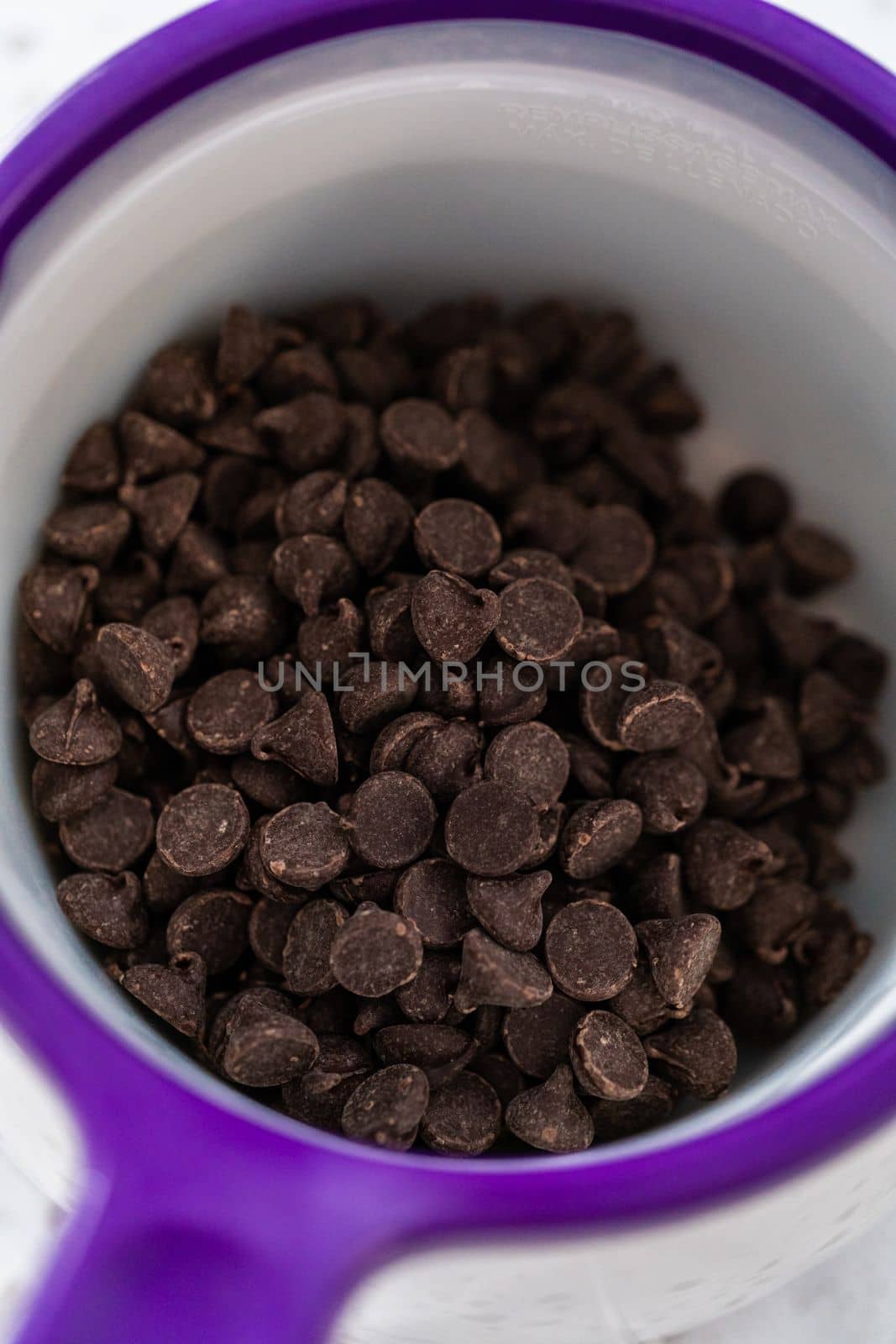 Melting chocolate chips in a candy melting pot to make a chocolate pretzel Christmas wreath.