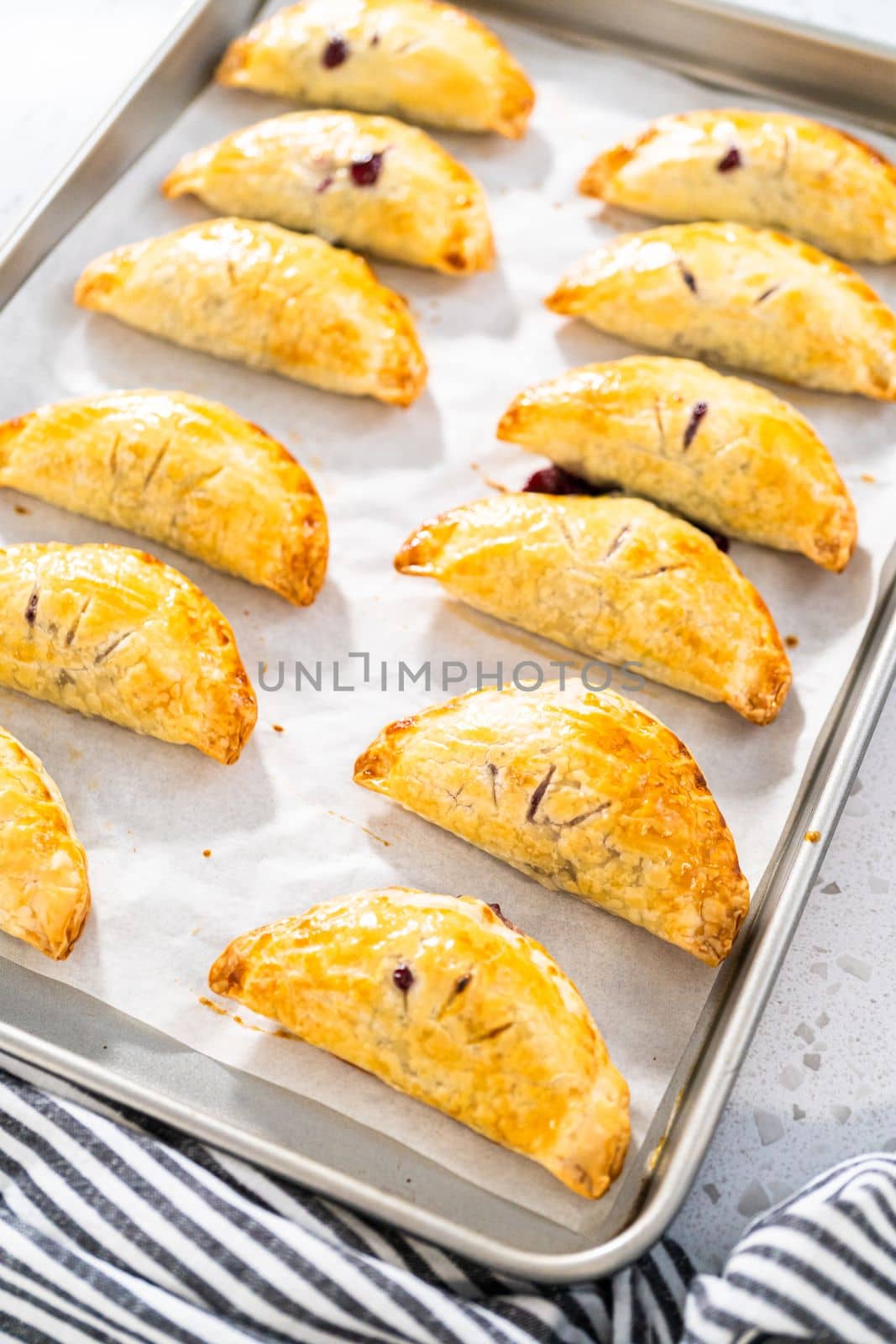 Freshly baked sweet empanadas with blueberries on the kitchen counter.