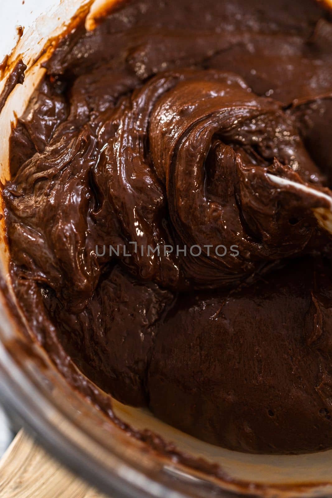 Melting chocolate chips and other ingredients in a glass mixing bowl over boiling water to prepare plain fudge.