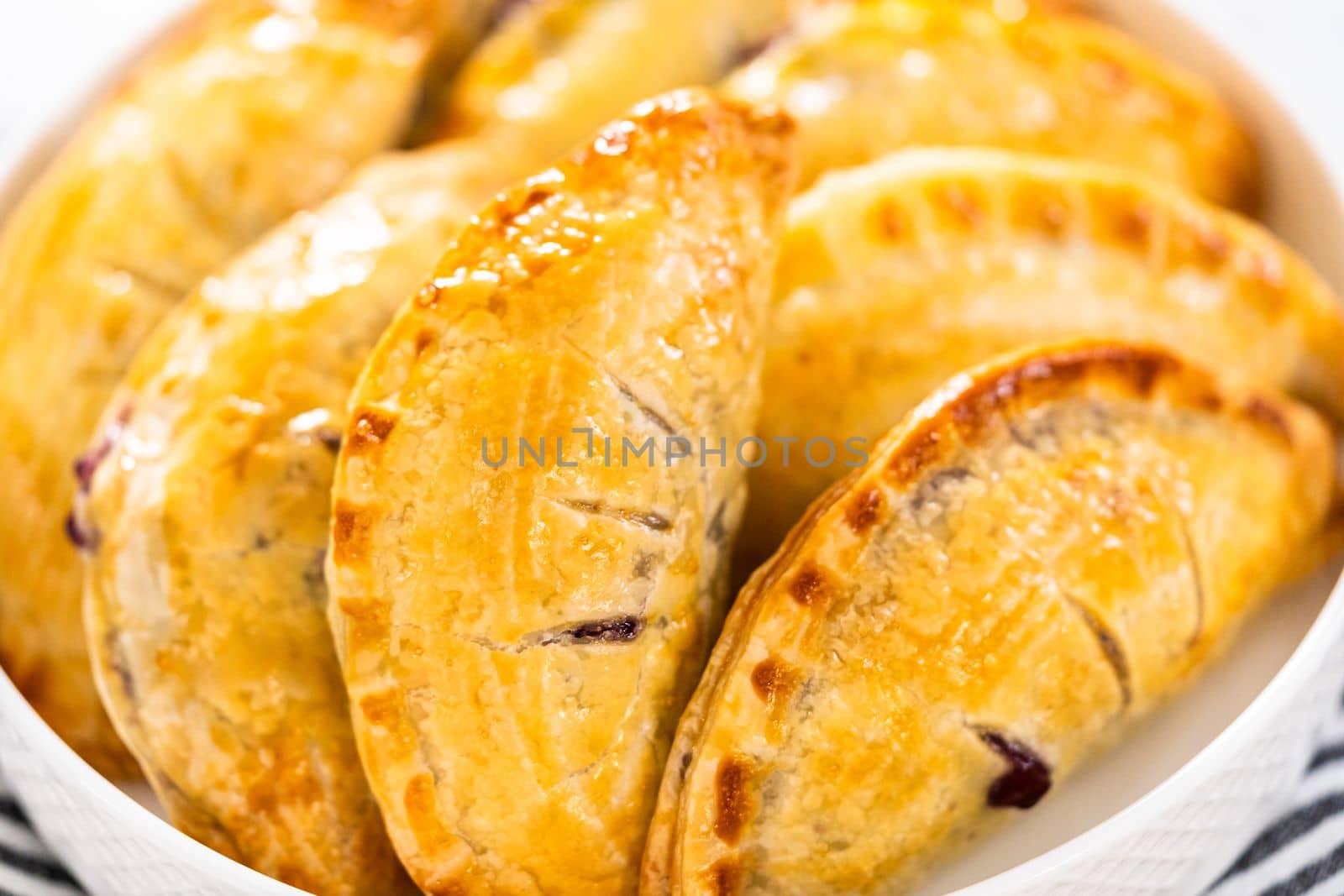 Freshly baked sweet empanadas with blueberries on the kitchen counter.