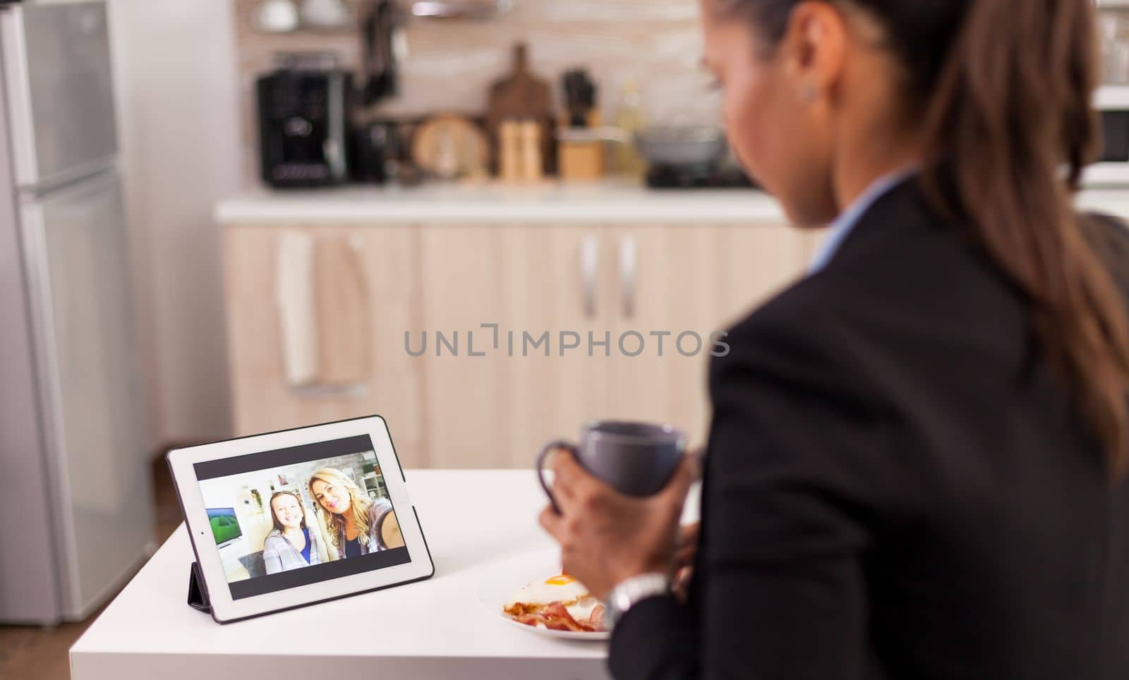 Woman in business suit talking online with friends on a digital tablet