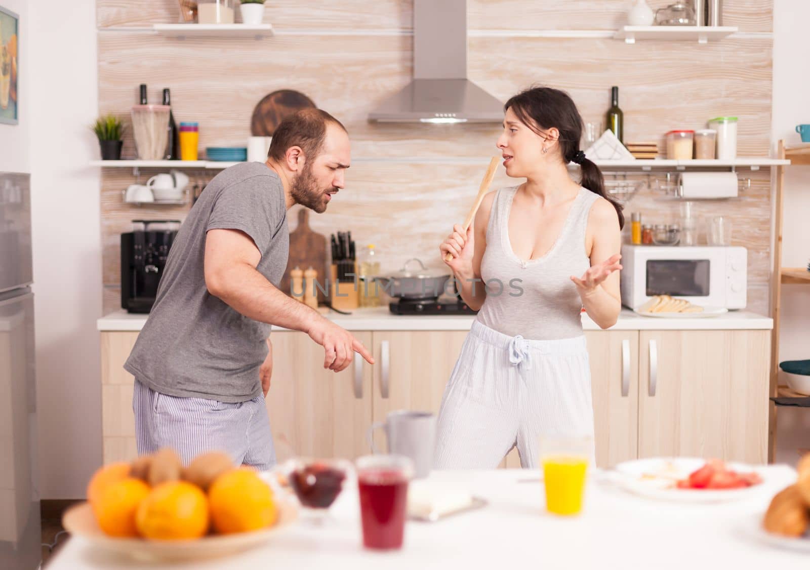 Cheerful couple dancing in kitchen by DCStudio