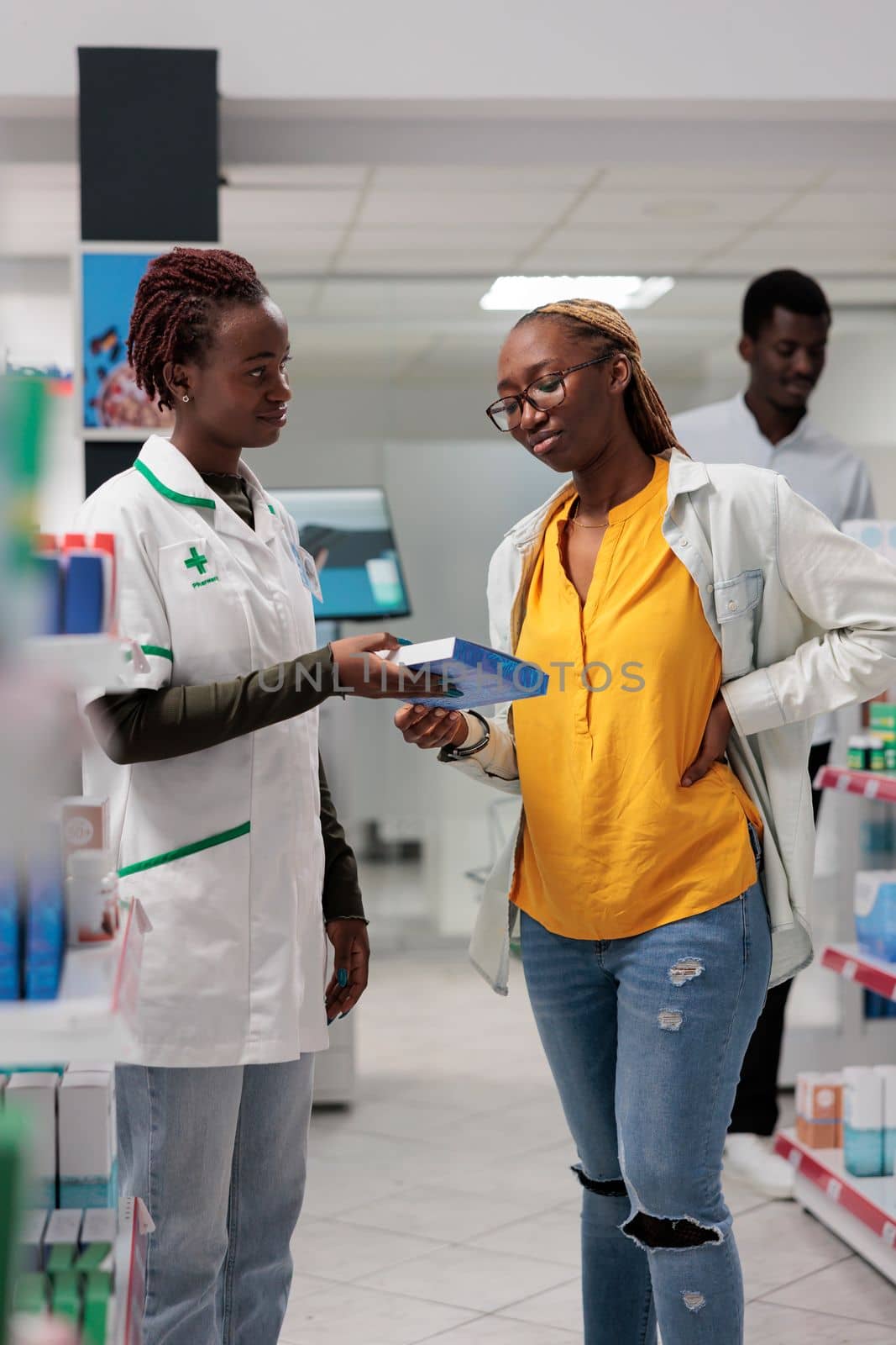 Customer buying back pain medication in drugstore by DCStudio