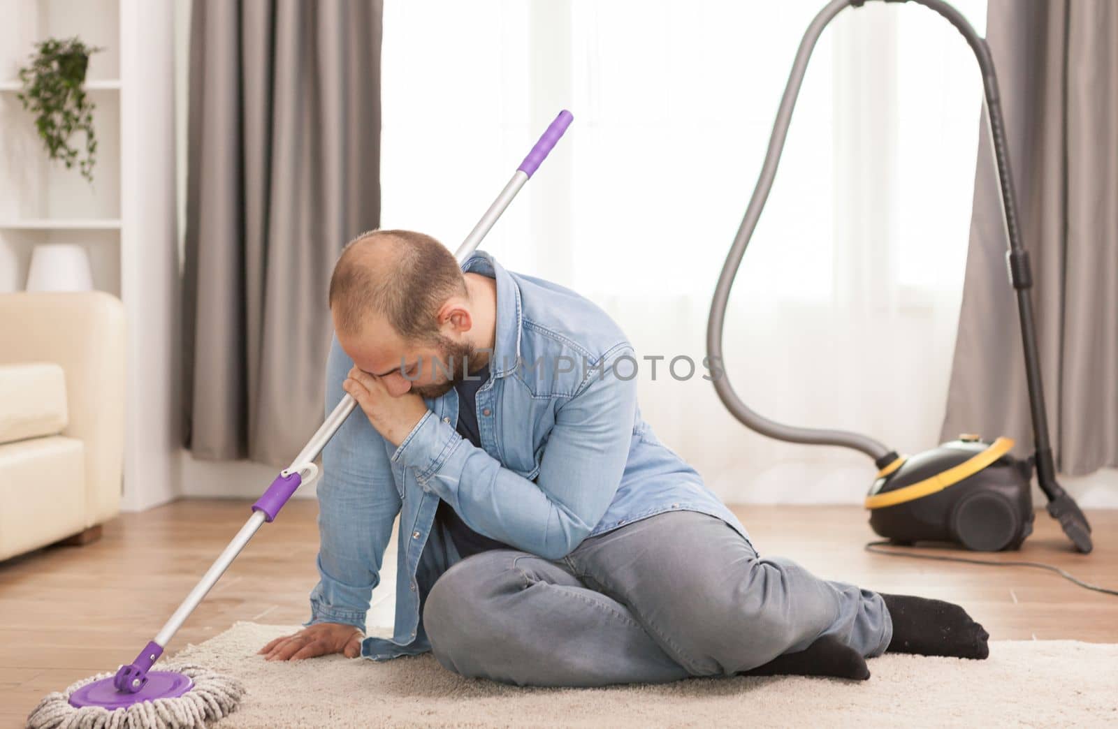 Exhausted husband on rug after housekeeping.