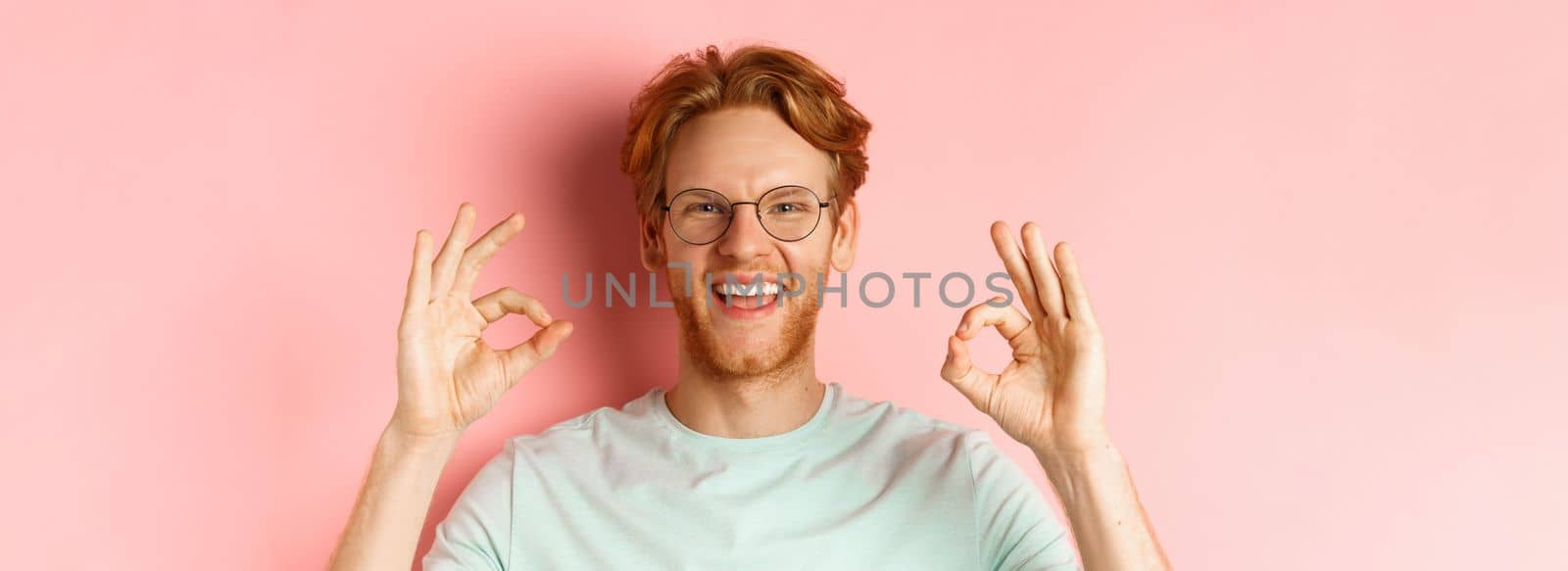 Headshot portrait of attractive young man with messy red hair and beard, wearing glasses, smiling with white teeth and showing Ok signs in approval, praise something good by Benzoix