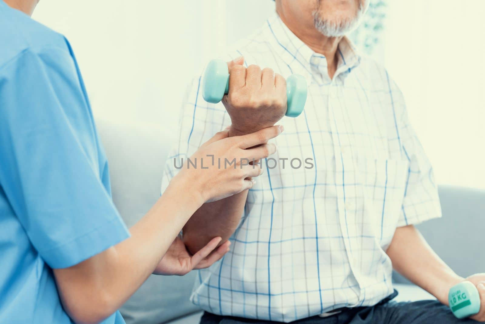 Contented senior patient doing physical therapy with the help of his caregiver. Senior physical therapy, physiotherapy treatment, nursing home for the elderly