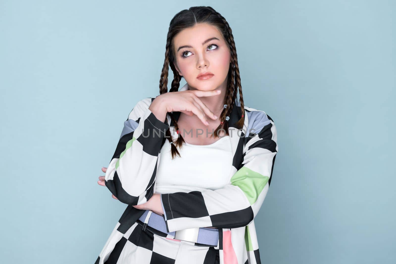 Closeup beautiful young girl with perfect skin, cosmetic and long braid posing with trendy fashion outfit in the studio with isolated background. charming young teenage with beauty gesture.