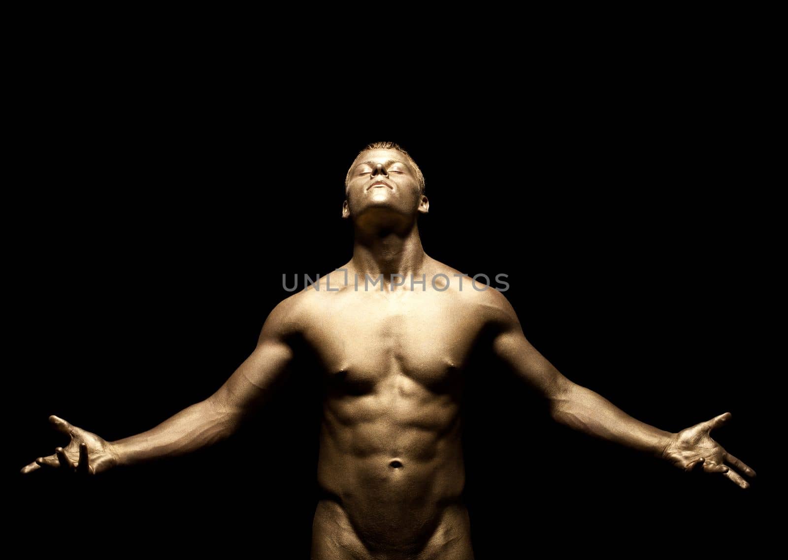 Beauty strong man stand under light with gold skin