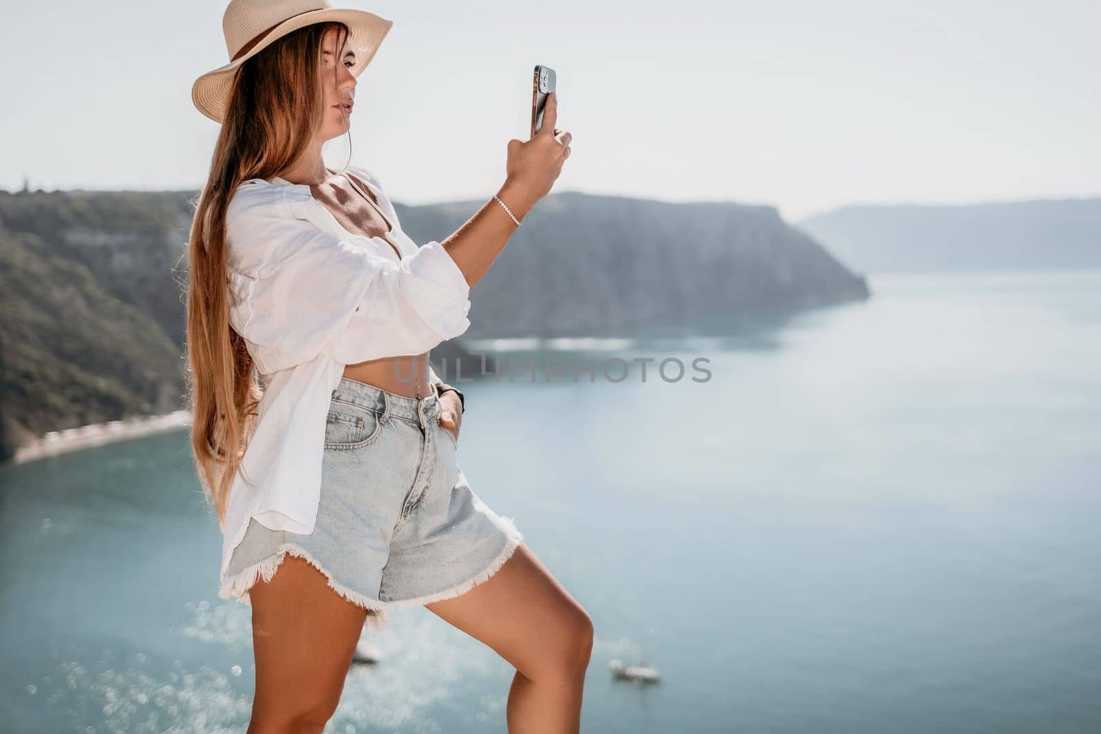 Woman sea laptop. Business woman in yellow hat freelancer with laptop working over blue sea beach. Girl relieves stress from work. Freelance, digital nomad, travel and holidays concept by panophotograph