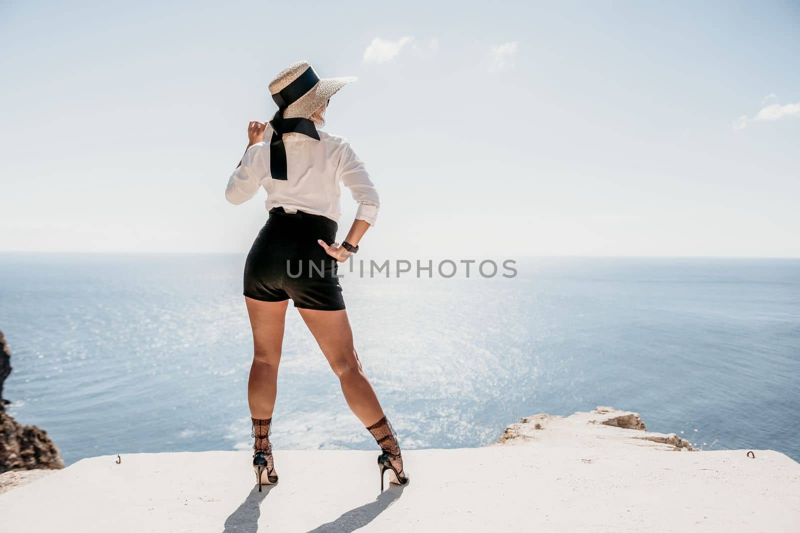 Woman sea hat. Business woman in yellow hat freelancer working over blue sea beach. Girl relieves stress from work. Freelance, digital nomad, travel and holidays concept by panophotograph