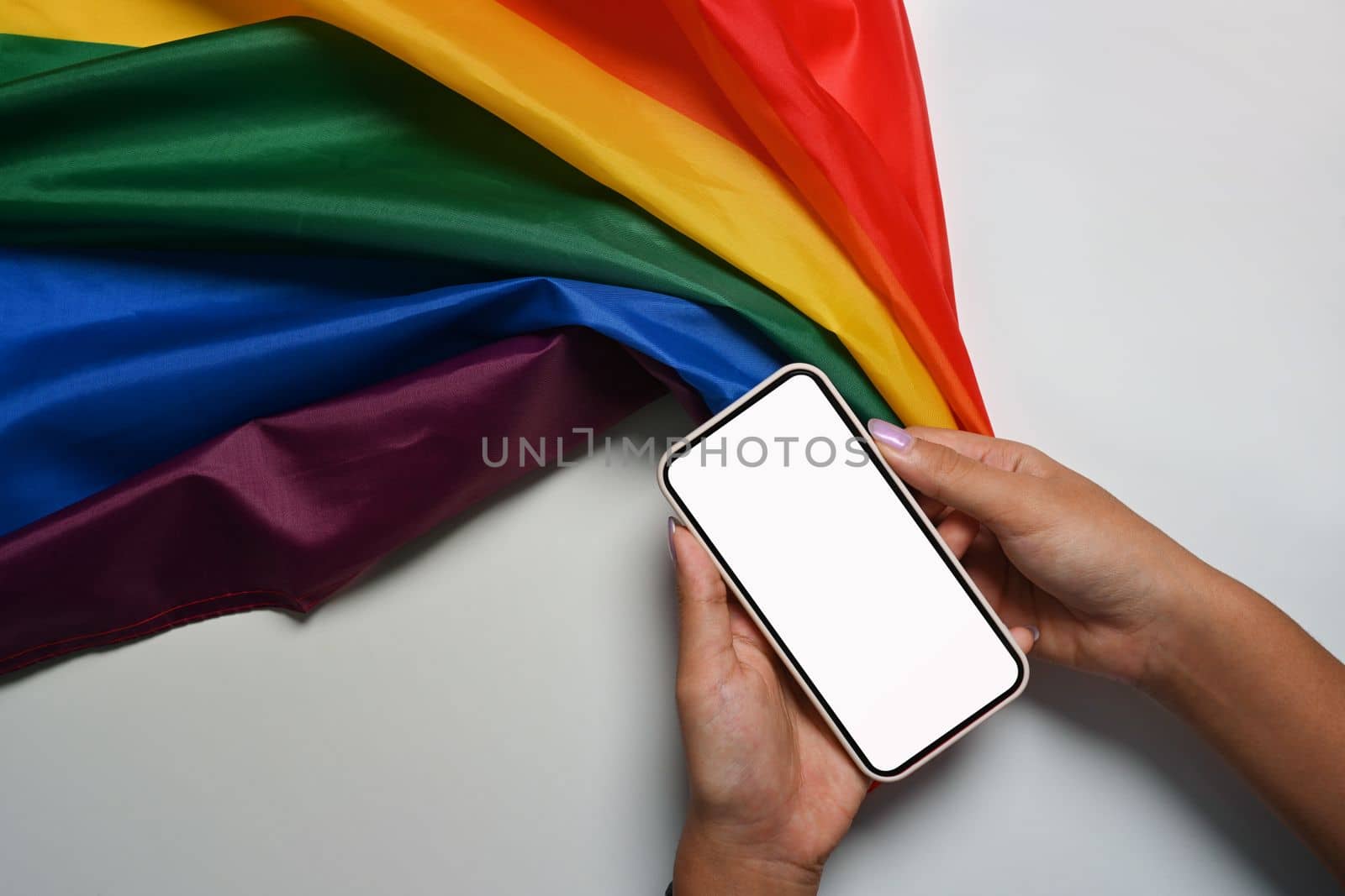 Man holding smart phone with rainbow flag. LGBT concept.