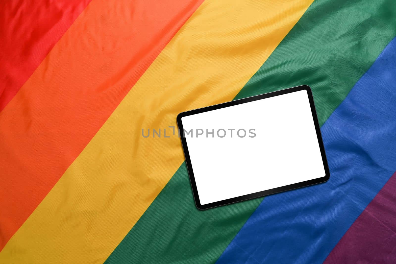 Mock up digital tablet on colorful rainbow flag.