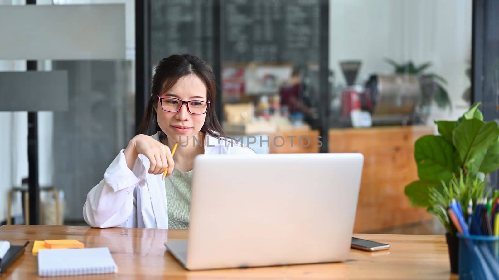 Asian woman freelancer working with computer laptop at cafe.